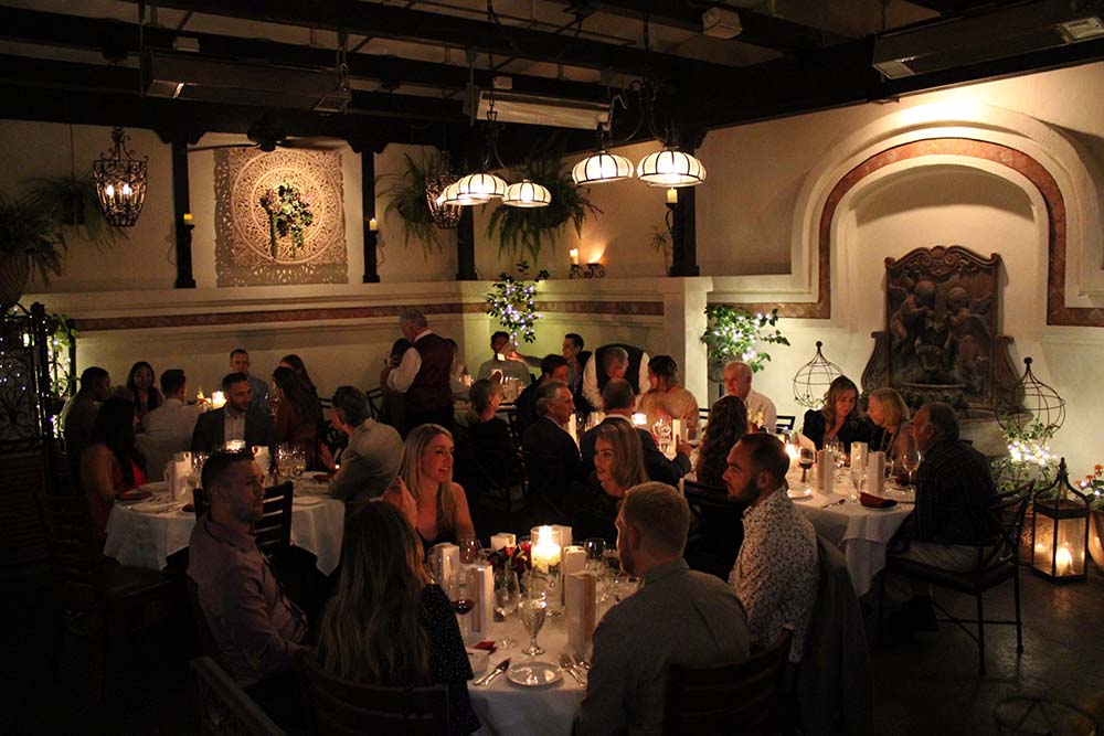 Guests seated around dining tables at 20th Anniversary party